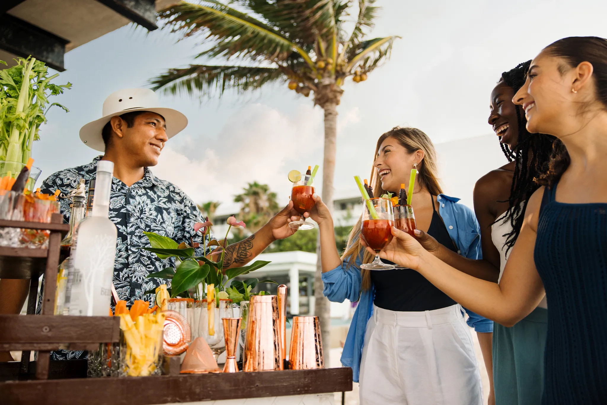 Guests enjoying handcrafted Bloody Mary cocktails at the beachfront bar at Breathless Riviera Cancun, an adults-only luxury all-inclusive resort in Mexico.