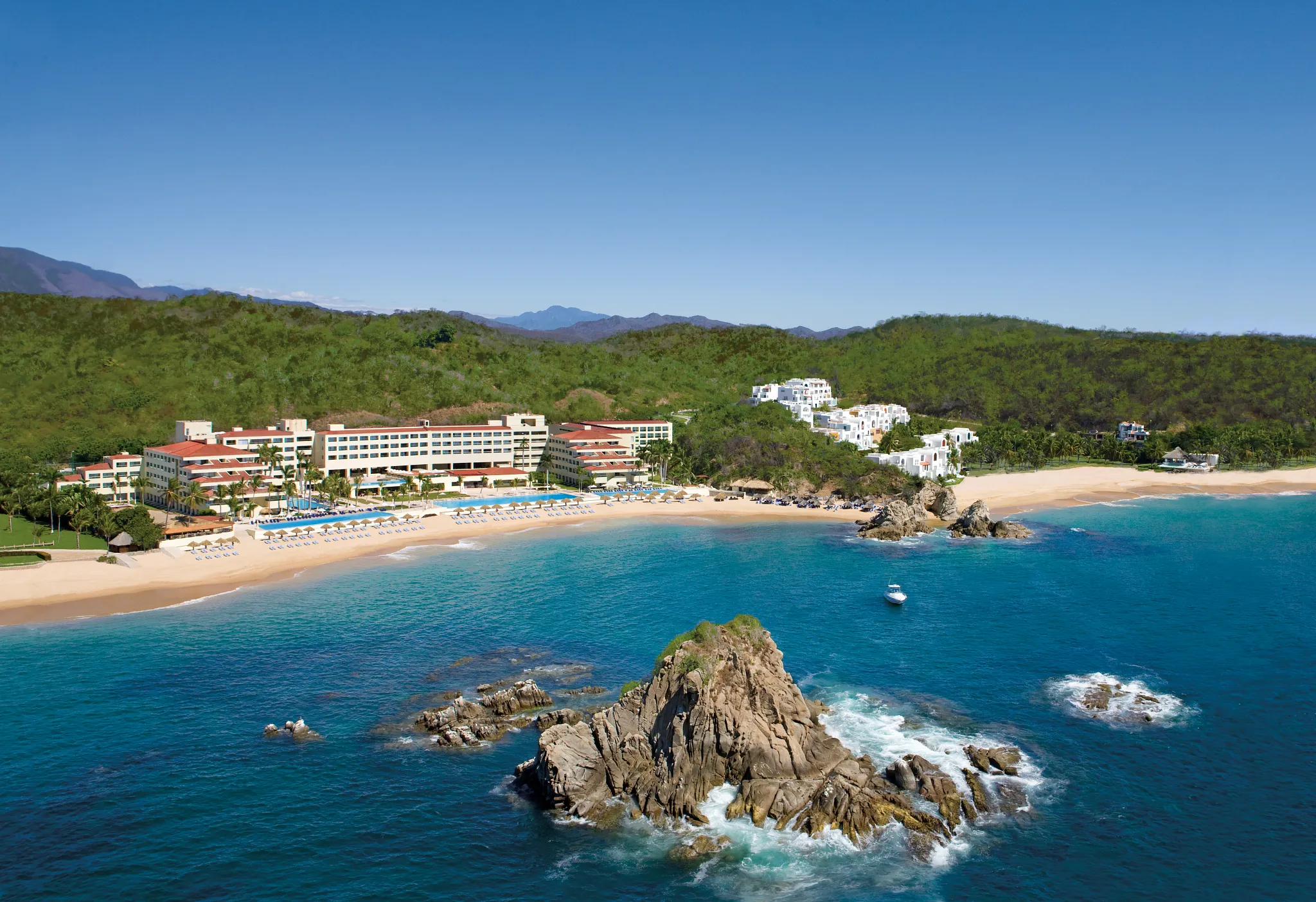 Aerial view of Dreams Huatulco Resort & Spa along a secluded beach and turquoise waters in Huatulco, Mexico.