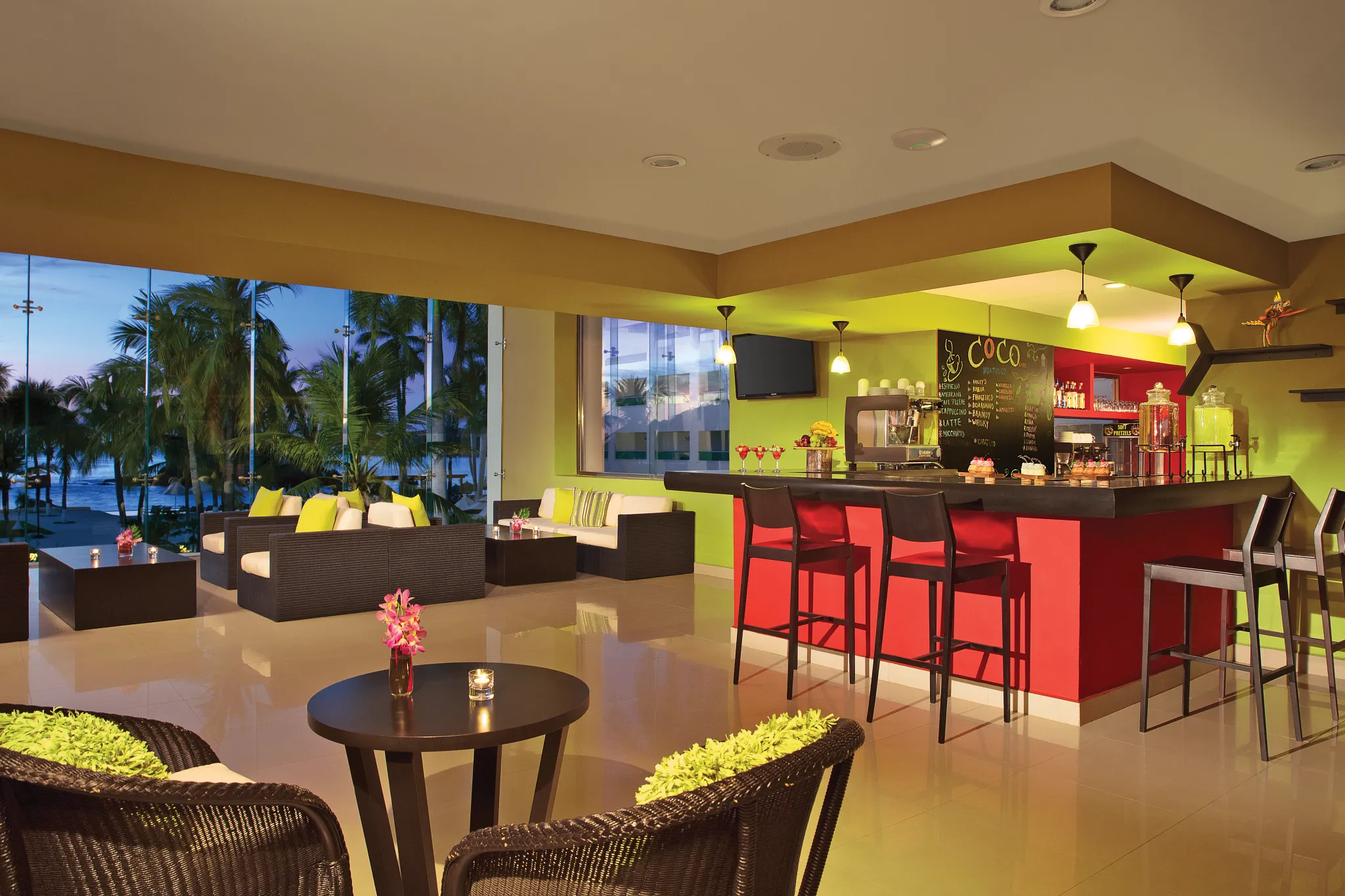 Coco Café at Dreams Huatulco Resort & Spa featuring a modern indoor coffee bar, cozy lounge seating, and tropical resort views.