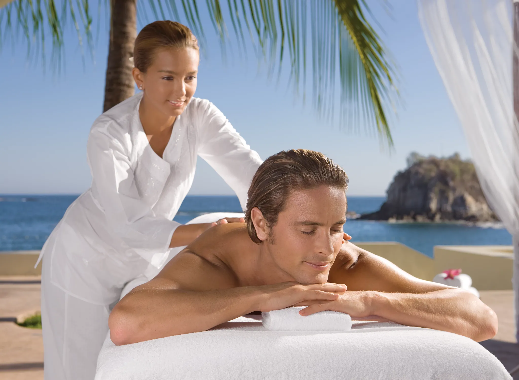 Outdoor beachfront massage with ocean views at Dreams Spa by Pevonia at Dreams Huatulco Resort & Spa.