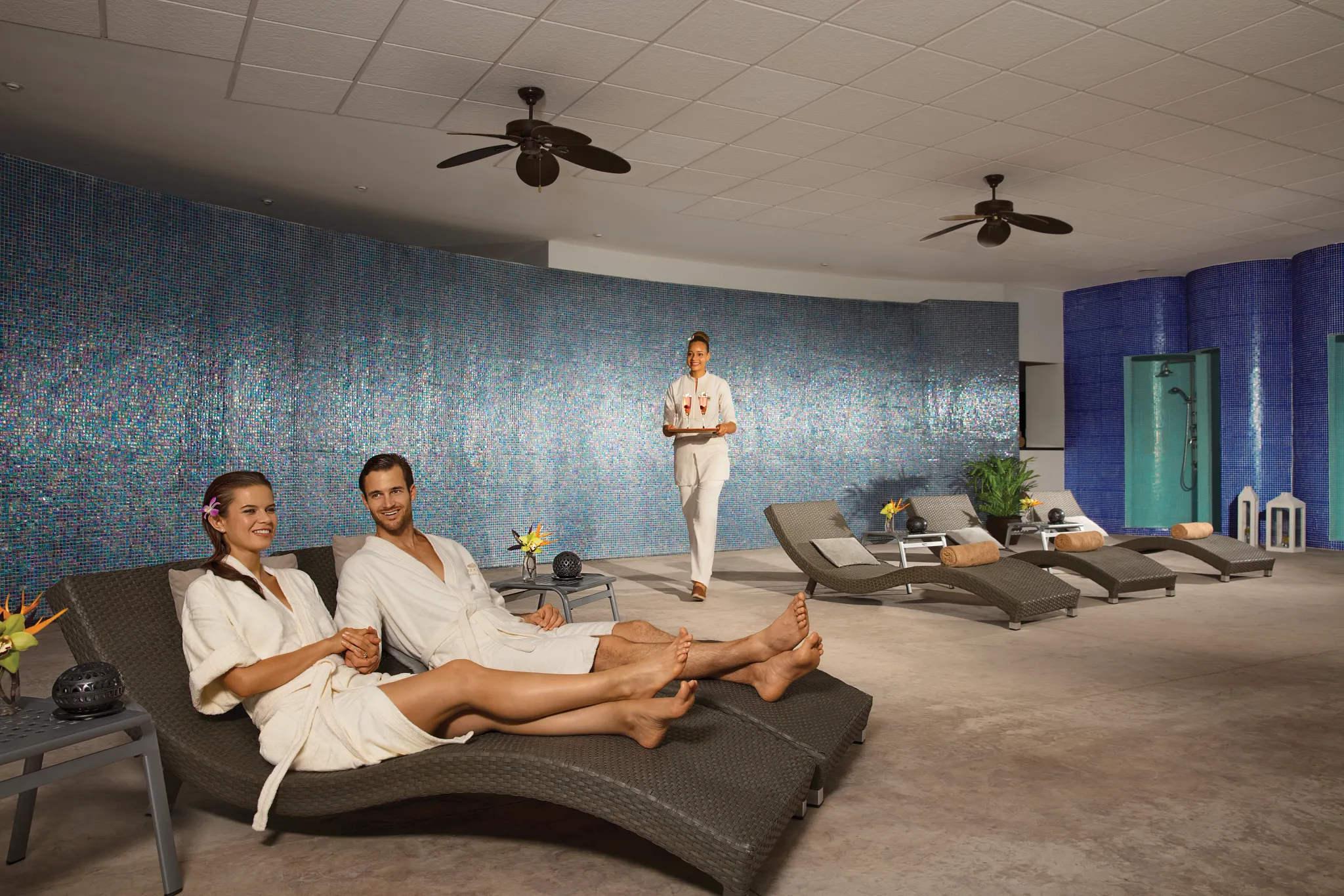 Couple relaxing on loungers in the spa relaxation area at Dreams Spa by Pevonia at Dreams Huatulco Resort & Spa.