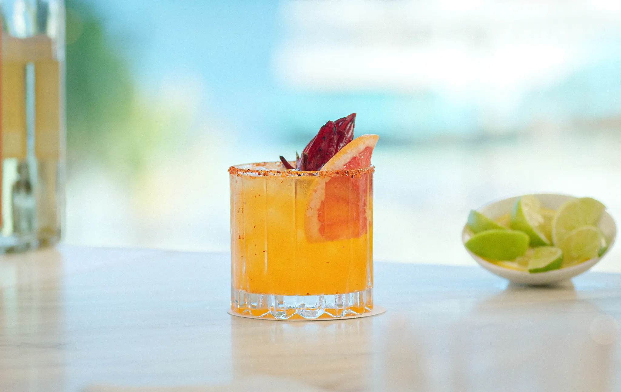 Mezcalería at Dreams Huatulco Resort & Spa featuring a handcrafted mezcal cocktail with citrus garnish in a relaxed beachfront-inspired setting.