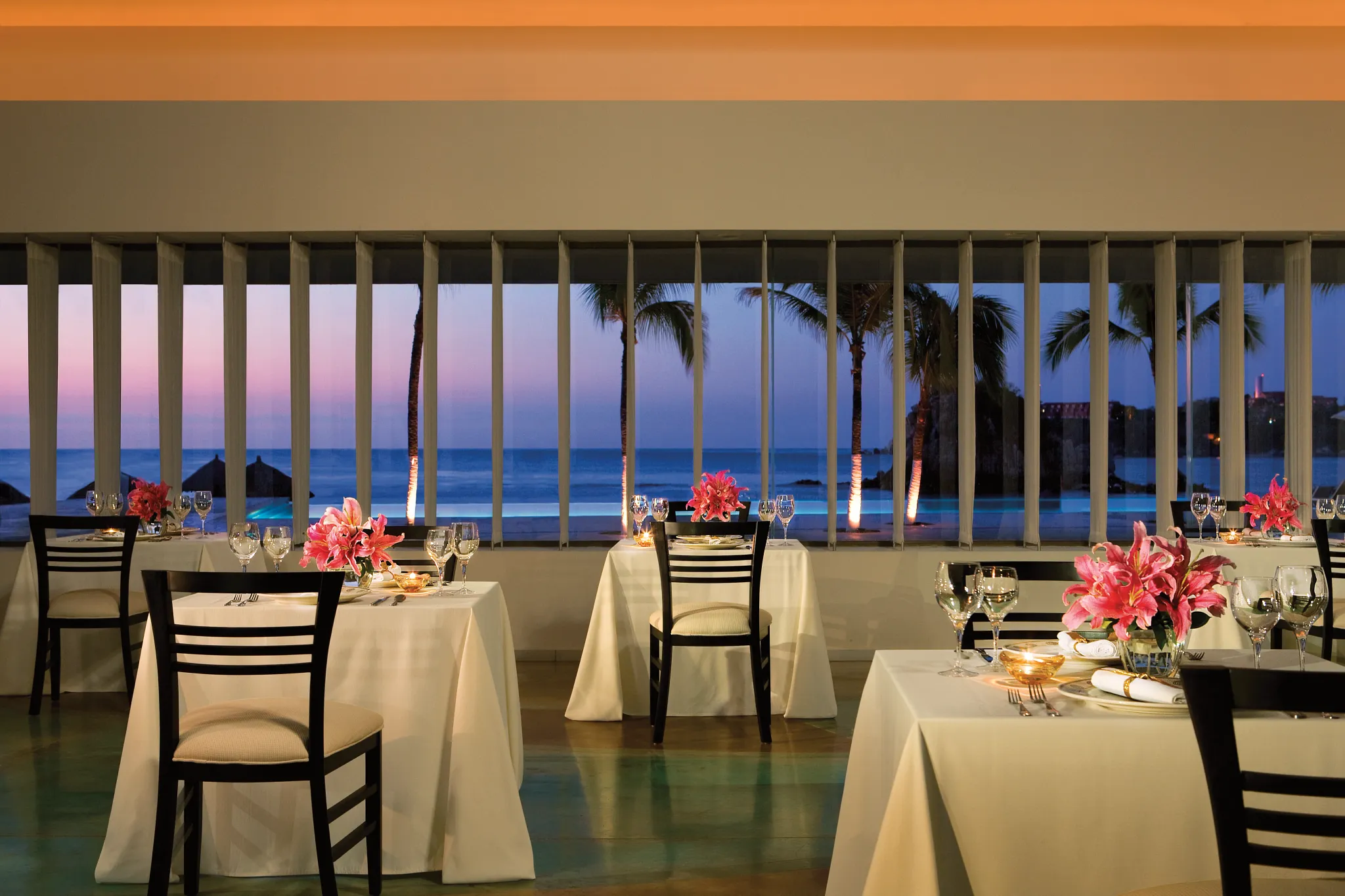 Portofino Italian restaurant at Dreams Huatulco Resort & Spa featuring elegant ocean-view dining, white tablecloths, and sunset views over the Pacific.