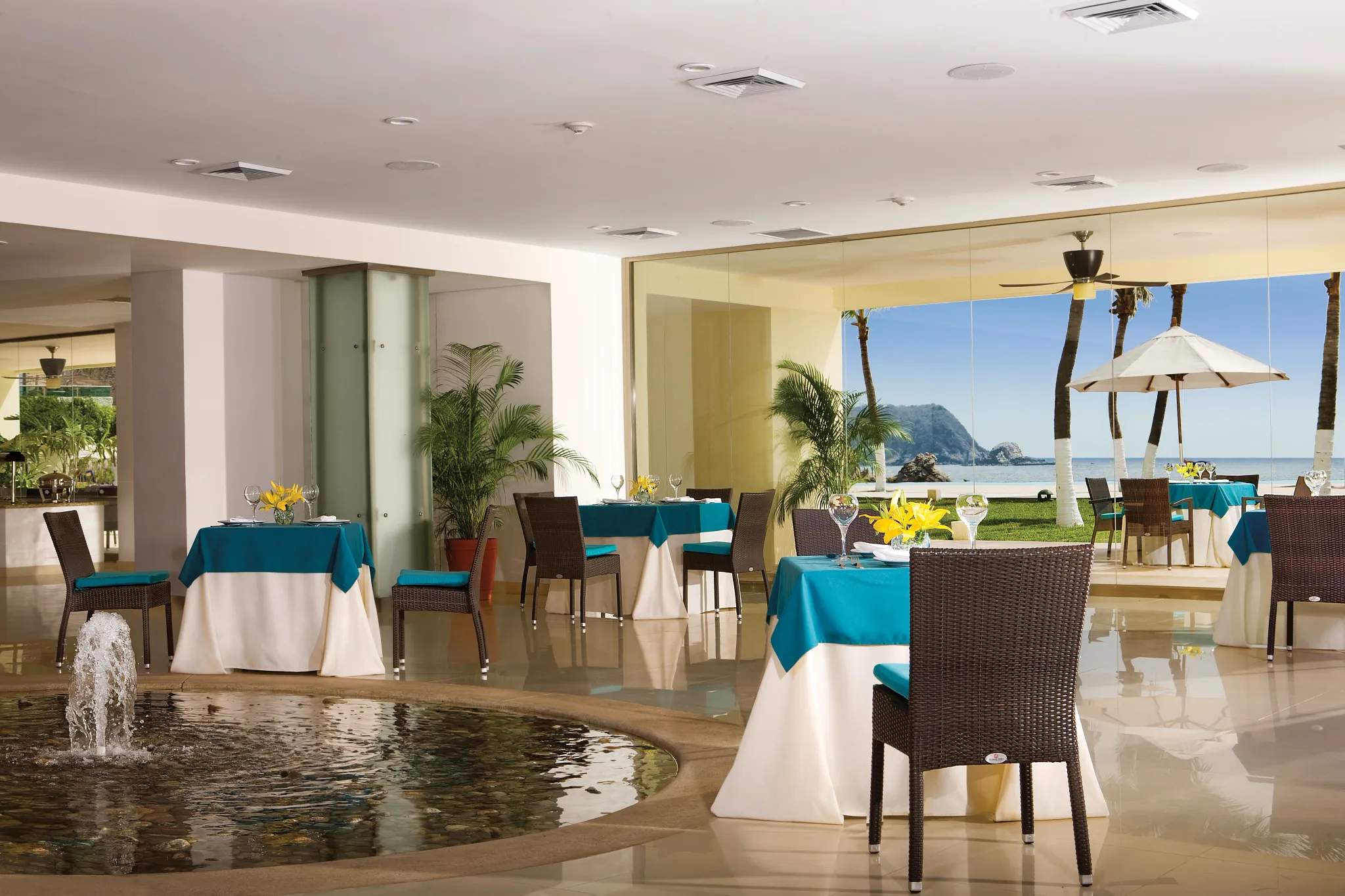 World Café at Dreams Huatulco Resort & Spa featuring an open, light-filled dining area, international buffet stations, and ocean-view seating.